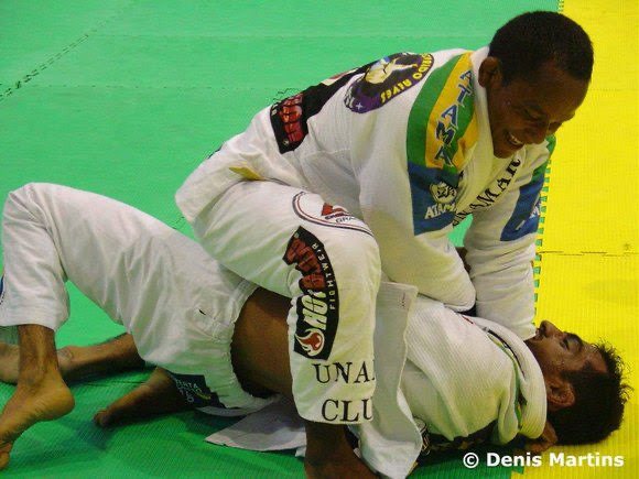 Fredson Paixão in 2003, in a white gi, on top of his opponent during a match on a green and yellow mat
