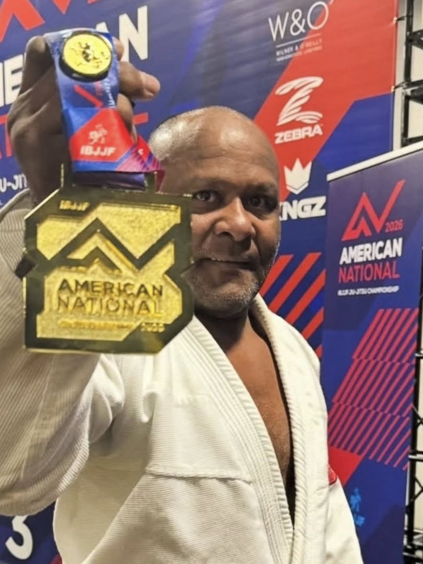Master Fredson Paixão holds up his gold medal from the 2026 IBJJF American Nationals