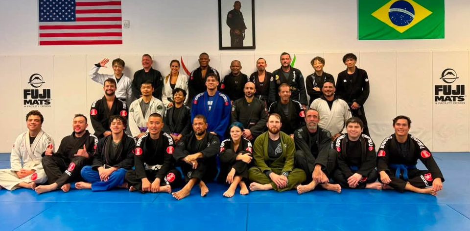 Students and coaches of the Academy together on the mat beneath the American and Brazilian flags