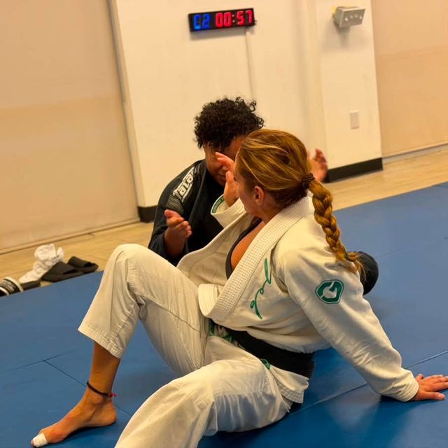 A black belt talks through a position with her training partner