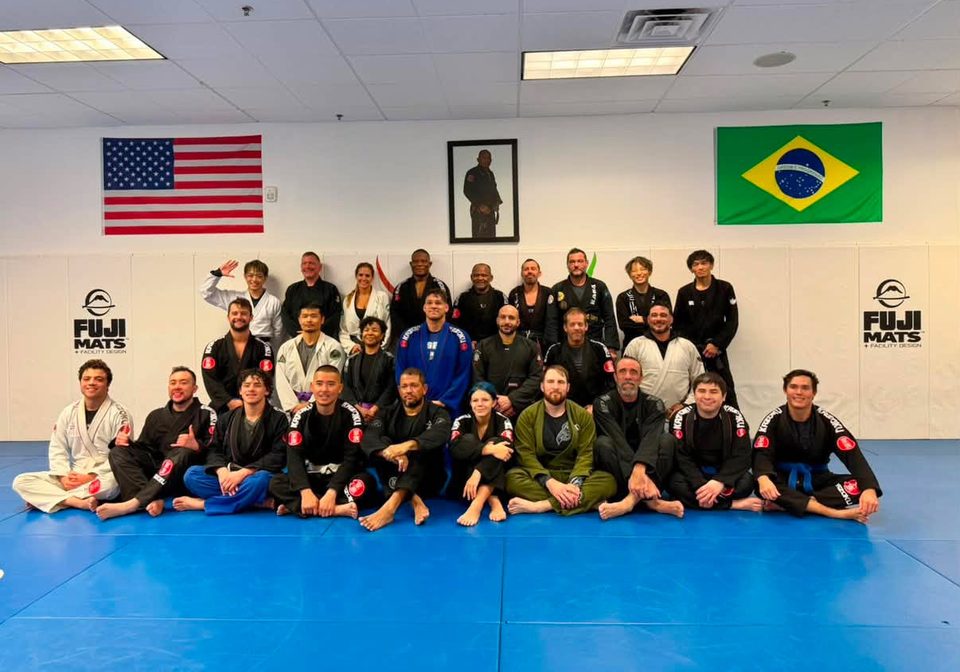 Students and coaches of the Academy together on the mat beneath the American and Brazilian flags